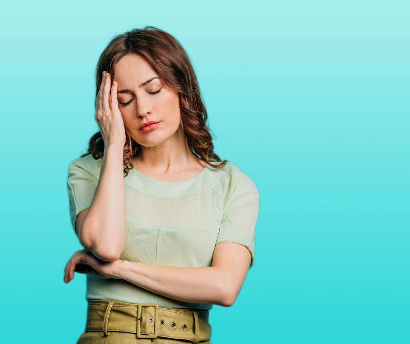 erschöpfte Frau greift sich an den Kopf und benötigt Hilfe durch TCM